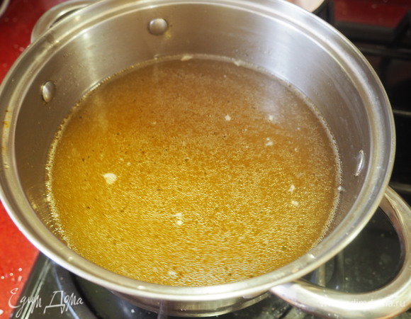 Готовый бульон отделяем от мяса и овощей и ставим на холод до образования сверху корочки из затвердевшего жира.