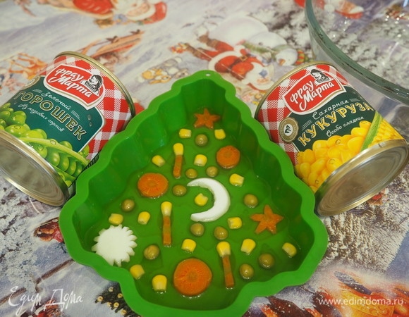 На дно формы или тарелки наливаем немного бульона с желатином и чесноком. Укладываем кусочки овощей, кукурузу, горошек. И немного поливаем сверху таким же бульоном. Ставим на холод до застывания.