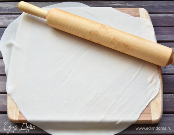 Подготовить пельменное тесто по вашему любимому рецепту. В данном рецепте я приготовила заварное тесто из муки (250 г), соли (1 щепотка), растительного масла (2 ст. л.) и кипятка (150 мл). Замешивать тесто вилкой, так как оно достаточно горячее. Когда немного остынет, перенести на рабочую поверхность и продолжить месить его руками. Тесто получается эластичным и мягким.