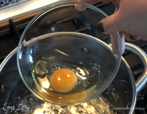 Вскипятить 1,5 литра воды. Когда вода закипит, убавить нагрев до минимума, добавить столовую ложку уксуса. Яйца разбить в отдельные чашечки и одно за другим аккуратно вылить в воду.