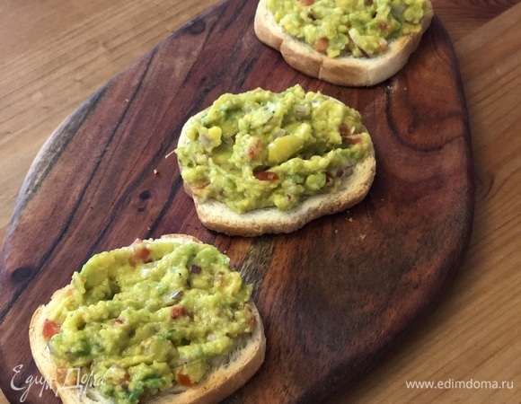 Начинаем собирать тосты. Выложите на хлеб массу из авокадо.