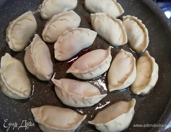 В сковороде на среднем огне разогреваем небольшое количество растительного масла. Выкладываем пельмени в один слой плоской стороной вниз. Жарим около 3 минут до легкого зарумянивания донышка.