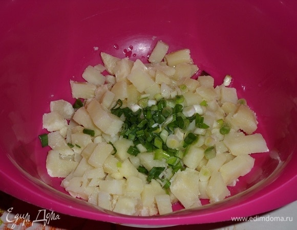 Выкладываем картофель и зеленый лук в чашку. Добавляем чесночное масло.