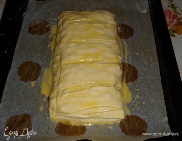 Смешиваем желток, воду и масло. Этой смесью смазываем пирог. Отправляем в разогретую духовку.