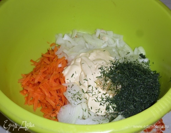 В глубокую чашку выкладываем нарезанный лук, натертую на терке морковь, оставшийся укроп и майонез. Добавляем измельченный чеснок.