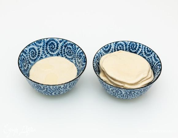 Подготовленные сочни по очереди сначала опустить в миску с растительным маслом, дать стечь лишнему маслу, а затем сложить все сочни стопочкой в свободную миску. Оставить сочни на 3–5 минут, чтобы они впитали масло, так легче будет растягивать.