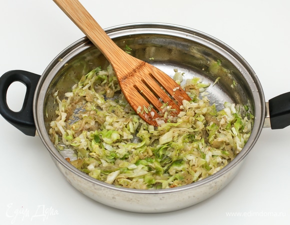 Пока тесто отдыхает, займитесь начинкой. В растительном масле слегка обжарьте лук (можете нарезать произвольно), затем добавьте нашинкованную капусту и слегка потушите. Добавьте соль и перец по вкусу, снимите с огня, а перед использованием добавьте белок 1 яйца, тщательно перемешайте. Желток отделите, он понадобится для смазывания пирожков.