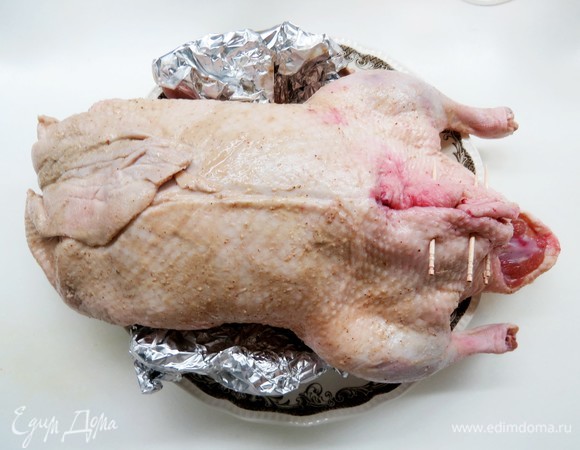 Заполнить утку яблочно-брусничной начинкой, брюшко зашить или сколоть зубочистками. Крылышки я обычно закрываю фольгой, чтобы не подгорели.