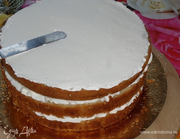 Поверх третьего коржа выкладываем крем. Равномерно распределяем. Я использовала шпатель.