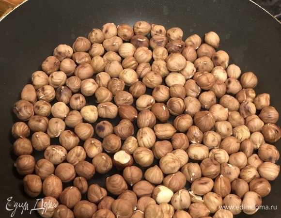 Пока мусс охлаждается, займёмся пралине. Обжарьте фундук на сухой сковороде, а затем очистите орехи от шелухи.