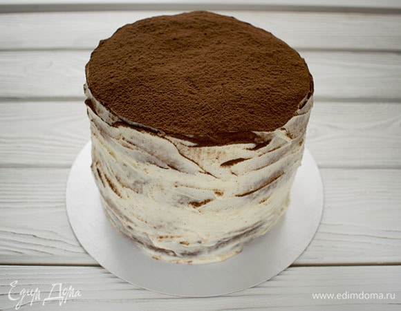 Собрать торт. Вниз положить корж с какао, затем два кофейных коржа, а сверху ванильный корж, прослаивая их кремом. Снаружи торт обмазать оставшимся кремом и посыпать сверху какао. Лучше торт подавать на следующий день.