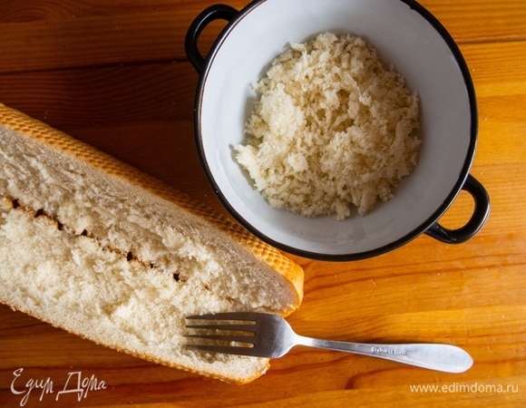 Батон надрезать с одного боку, постараться аккуратно открыть. Если багет сильно хрустящий, то разрезать пополам. Мякоть выскрести с помощью вилки. Отложить примерно треть мякоти, она пойдет в начинку.