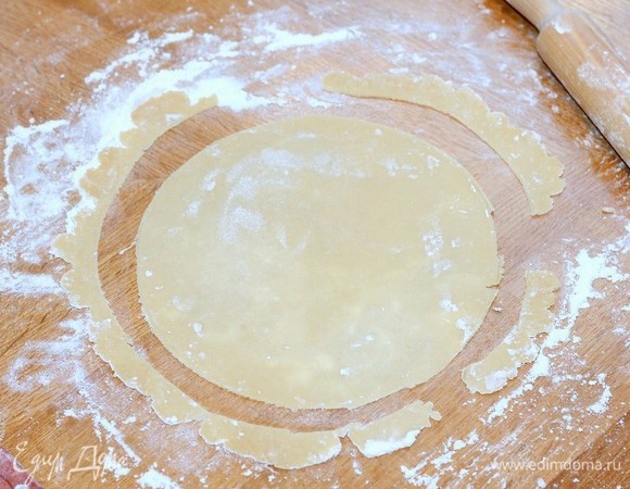 Напыляем разделочную доску мукой. Муки на раскатку уходит очень много. Из каждой части теста, раскатываем тонкий пласт и при помощи тарелки, вырезаем круги, форма — 18 см.