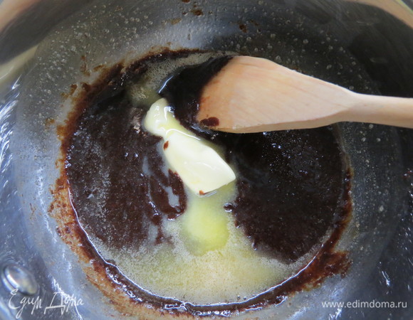 Когда сахар растопится, ввести частями холодное сливочное масло, перемешать до однородности.