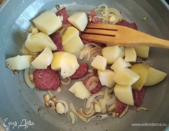 Вареный картофель нарезать крупными кубиками и добавить в сковородку. Аккуратно перемешать.