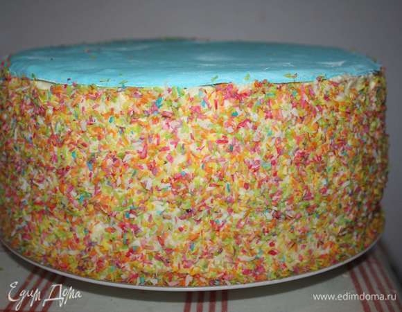 Далее украшаем бока торта цветной кокосовой стружкой. Сверху укладываем круг из мастики голубого цвета.