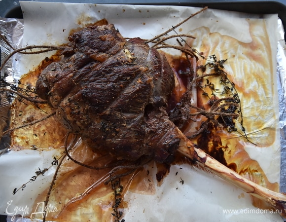 Из духовки достать баранью ногу. Освободить ее от шпагата и веточек тимьяна.