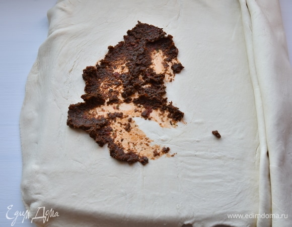 Слоеное тесто раскатать в пласт толщиной 0,5 мм. Распределить по нему часть подготовленной топинады. Остальной частью обмазать готовую баранью ногу.