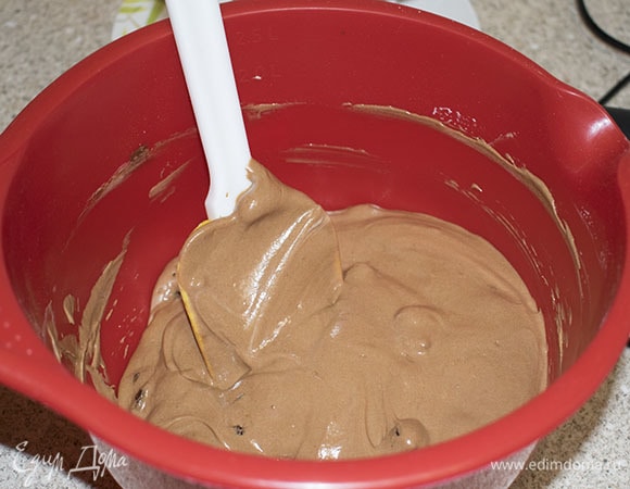 Ввести половину белков в шоколадное тесто и аккуратно перемешать, затем добавить оставшуюся часть и снова перемешать.