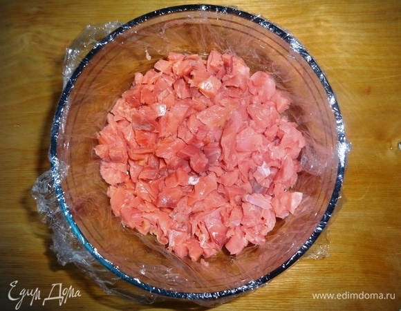 Форму подходящего размера (у меня вазочка диаметром 13 см и высотой 7 см) выстелить пищевой пленкой. Выложить слой нарезанной рыбы, слегка утрамбовать.