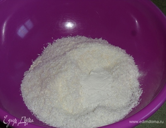 В чашку просеиваем муку. Добавляем сахар, разрыхлитель и кокосовую стружку. Хорошо перемешиваем.