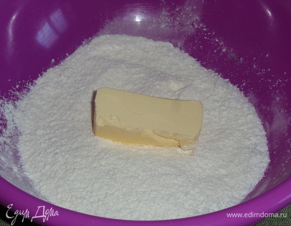 В чашку к смеси сухих ингредиентов добавляем охлажденное сливочное масло.