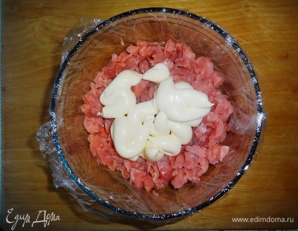 На рыбу выложить часть майонеза и распределить его по слою рыбы.