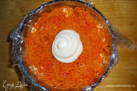 Морковь по-корейски (у меня домашняя, самодельная) отжать от маринада, выложить в форму следующим слоем, слегка утрамбовать. Положить часть майонеза и распределить его по моркови.