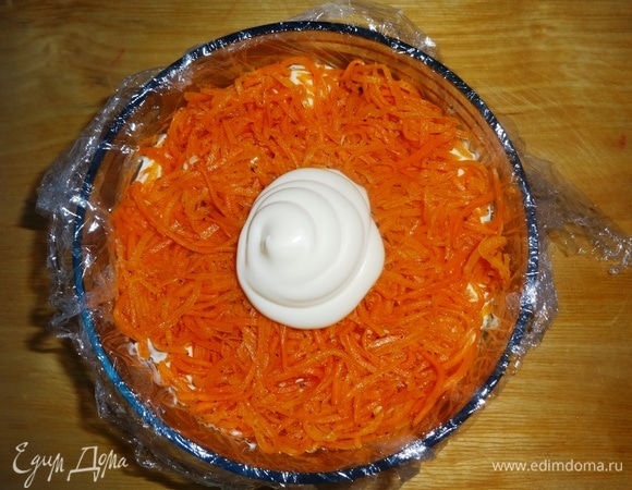 Морковь по-корейски (у меня домашняя, самодельная) отжать от маринада, выложить в форму следующим слоем, слегка утрамбовать. Положить часть майонеза и распределить его по моркови.