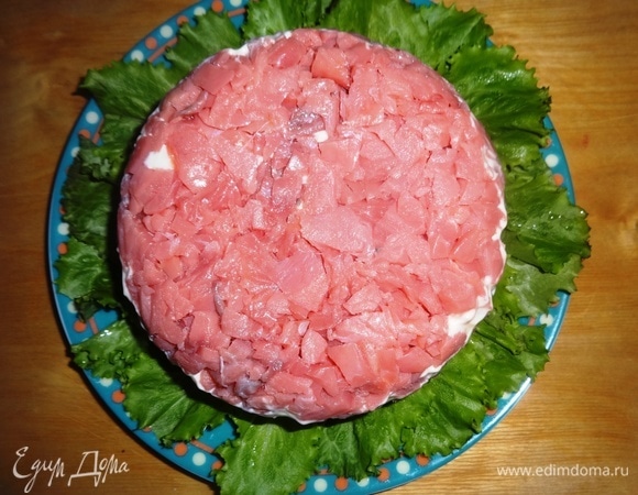 Аккуратно перевернуть форму с салатом на блюдо с листьями, убрать пищевую пленку.