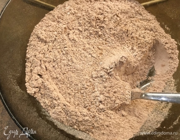 В отдельной миске смешиваем сухие ингредиенты: просеиваем 260 г муки и 7 г разрыхлителя, добавляем 1,5 ч. л. корицы, 1 ч. л. кардамона, 1 ч. л. мускатного ореха, 3 ст. л. какао и тщательно перемешиваем. Количество пряностей может быть меньше, добавляйте на свой вкус. С данным количеством получаются коричневые, достаточно пряные печеньки.