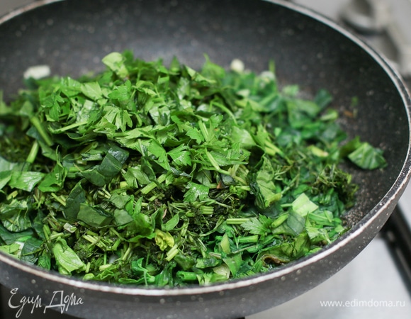 Добавьте остальную зелень к луку, перемешайте и через минуту выключите огонь, чтобы зелень не сильно потушилась, а шпинат не пустил сок.