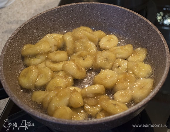 Когда начнут появляться пузырьки, добавить в сковороду бананы, перемешать и жарить 3–4 минуты на среднем огне, пока бананы не станут красивого золотистого цвета.