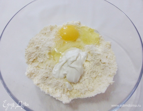 Добавить сахарную пудру, разрыхлитель, яйцо и сметану.