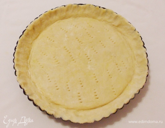 Затем тесто раскатать, перенести в форму (у меня форма диаметром 28 см, высота бортиков — 4 см). Сформировать бортики, наколоть тесто вилкой.