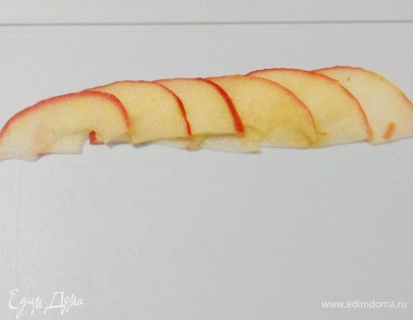 Теперь начинается самое интересное. Выложить 6 долек яблок внахлест. Затем завернуть в розочку. Делайте так, как вам удобно. Я сворачивала дольки на разделочной доске лежа. Можно поставить дольки на доске вертикально и так завернуть розочкой. Можно заворачивать розочку, держа в руках, добавляя постепенно по одному лепестку. Довольно скоро вы найдете удобный для вас вариант.