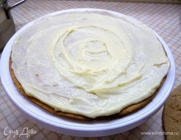 Собираем торт на подложке или большой тарелке. На первый корж распределяем крем, затем укладываем второй корж.