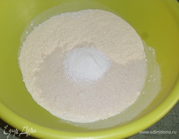 В чашку просеиваем оба вида муки. Добавляем сахар и разрыхлитель. Хорошо перемешиваем ингредиенты.