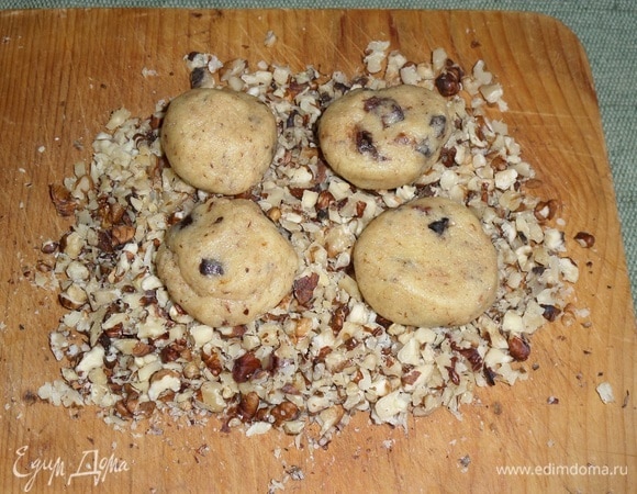 Выкладываем шарики в измельченные орехи. Слегка прижимаем руками, придавая тесту форму лепешки.