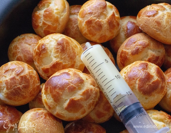 Крем переложить в кондитерский мешок с круглой насадкой 0,5 см (или меньше) в диаметре и начинить каждый профитроль. Если нет специальной насадки, можно использовать обычный шприц на 10–20 мл. Приятного аппетита!