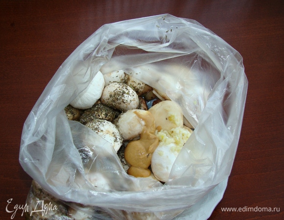 Все ингредиенты добавить к грибам прямо в пакет. Чеснок пропустить через пресс.
