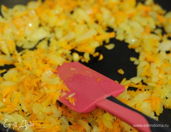 Добавляем к луку натертую морковь.