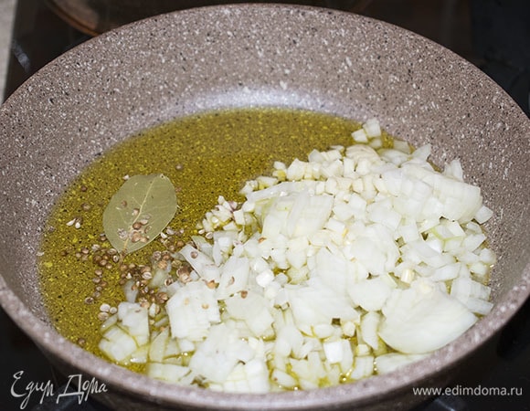 В глубокой сковороде обжарить на оливковом масле лук, чеснок, зерна кориандра и лавровый лист до прозрачности лука. Следите, чтобы овощи не потемнели, а лишь стали прозрачными. Зерна кориандра предварительно следует слегка раздавить — так они дадут больше аромата.