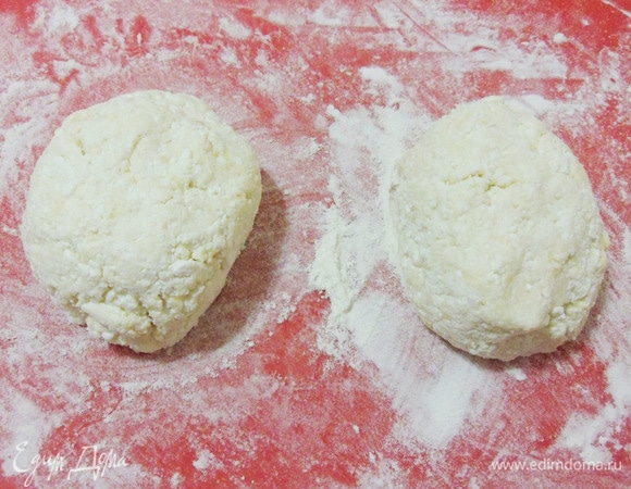 Посыпать рабочую поверхность мукой и разделить тесто на 2 равные части.