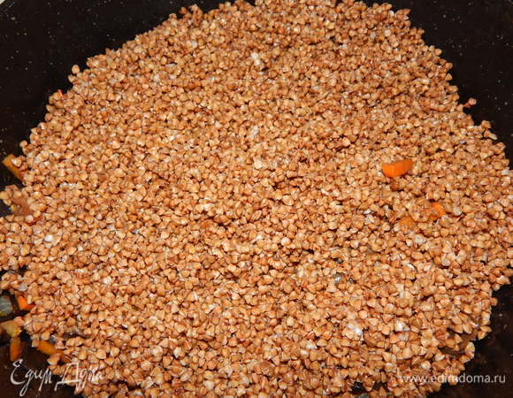 Гречу ТМ «Националь» промываем и выкладываем в сковороду к овощам. Вливаем 1,5 стакана воды и тушим под закрытой крышкой до полуготовности гречки.