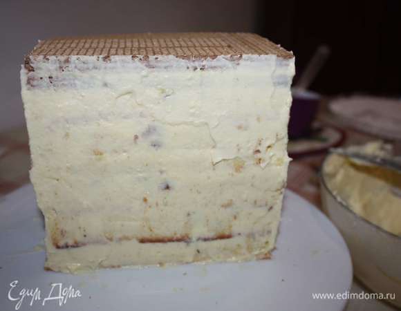 На последний слой уложим два слоя с шоколадными вафлями. Бока дома тоже обмажем кремом.