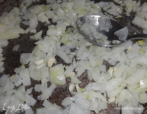 В сковороду налить растительное масло, разогреть, выложить лук и чеснок и обжарить до прозрачности.
