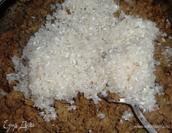 Добавить рис в теплый фарш, перемешать.