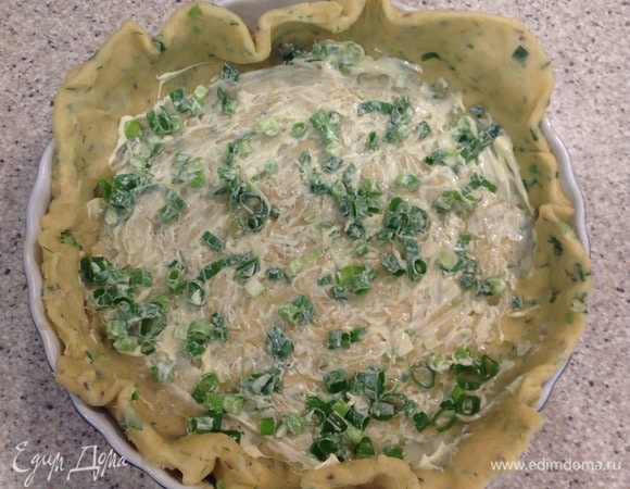 Смазать форму сливочным маслом, выложить тесто. Сметаной хорошо смазать основу пирога и посыпать зеленым луком. Поставить в холодильник, пока готовим грибы.