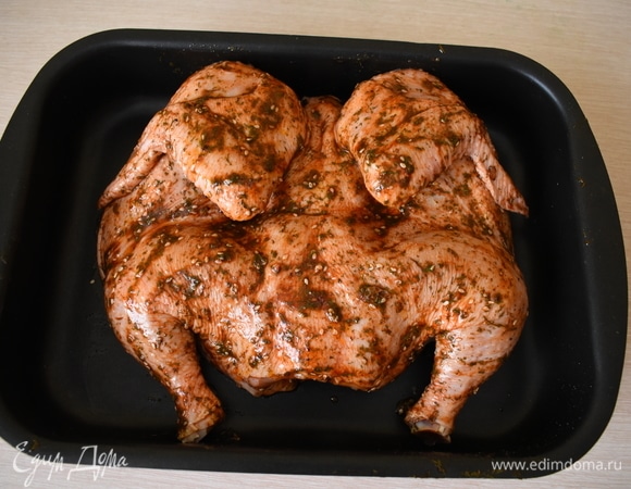 Кладем нашу курочку на чистый противень, где будем запекать. Промазываем ее с двух сторон маринадом, уделяя особое внимание верхней части. Дополнительного масла лить на противень не надо. В маринаде его будет достаточно. И, опять же, напомню — количество ингредиентов меняйте на свой вкус.